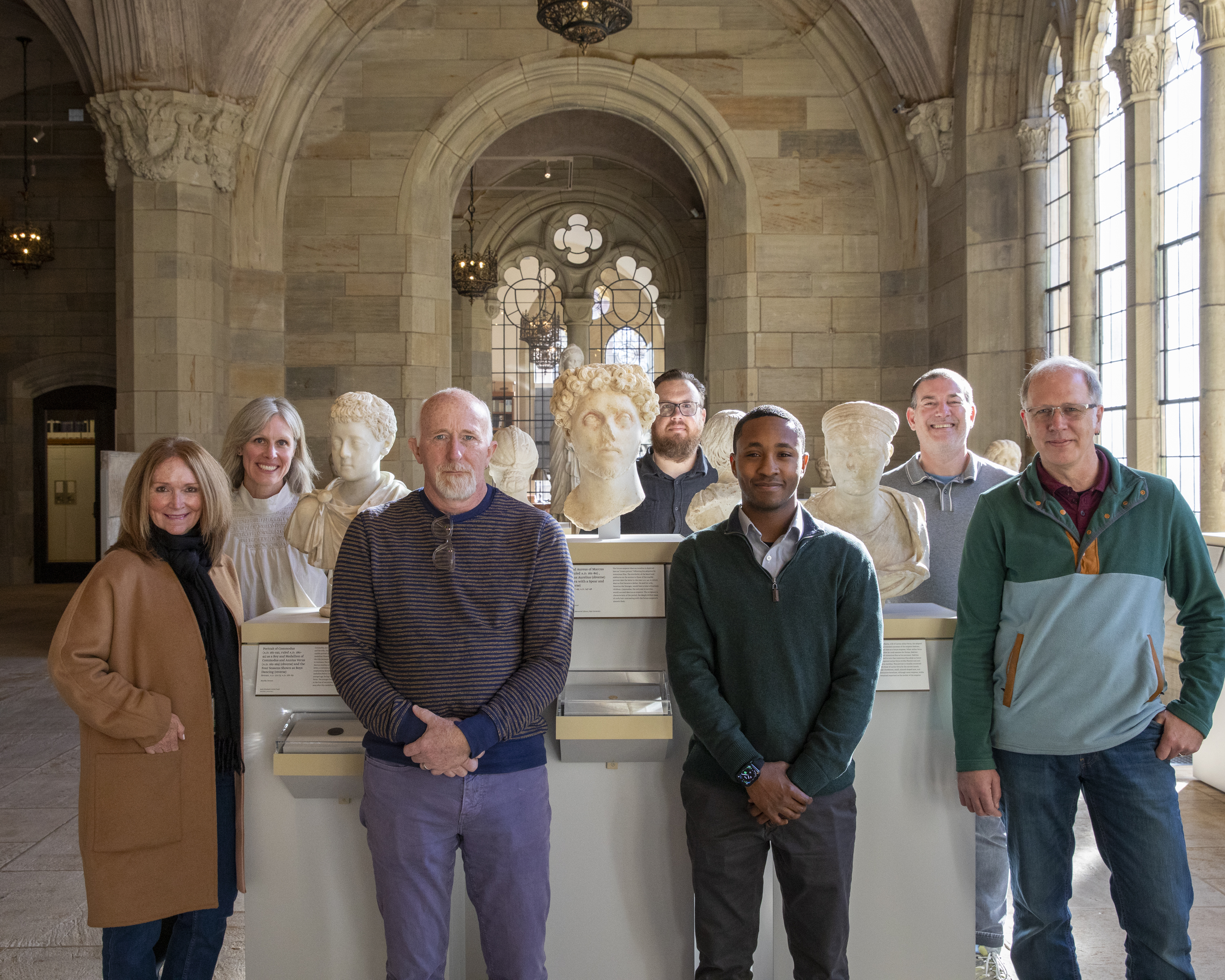 A group of people standing amongst busts