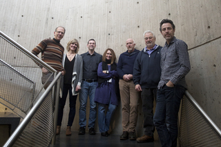 a group of people standing in a stairwell looking towards the camera