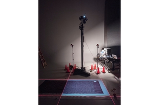 A textile in a photo studio with equipment surrounding it.