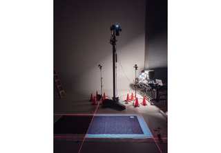 A textile in a photo studio with equipment surrounding it.